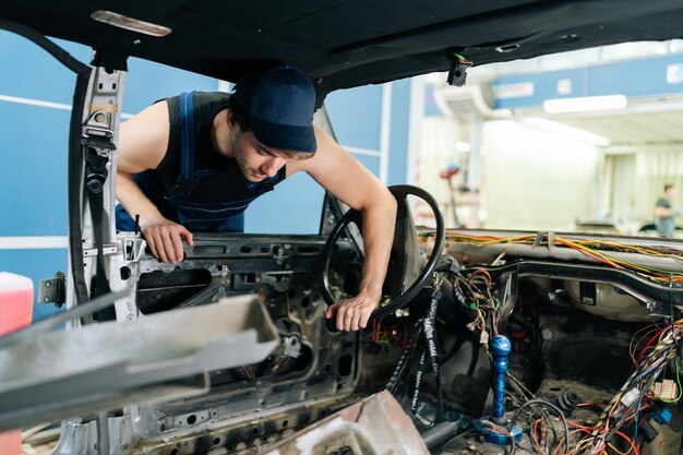 mechanic working on a steering wheel in a car shell